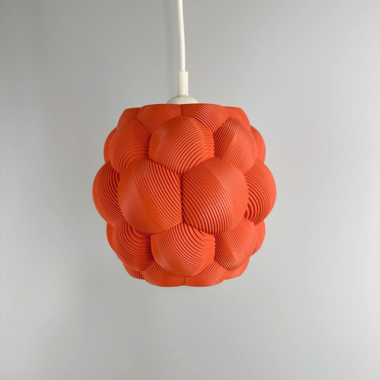 3D printed Apo Malli lampshade in modern design in muted red biodegradable material.