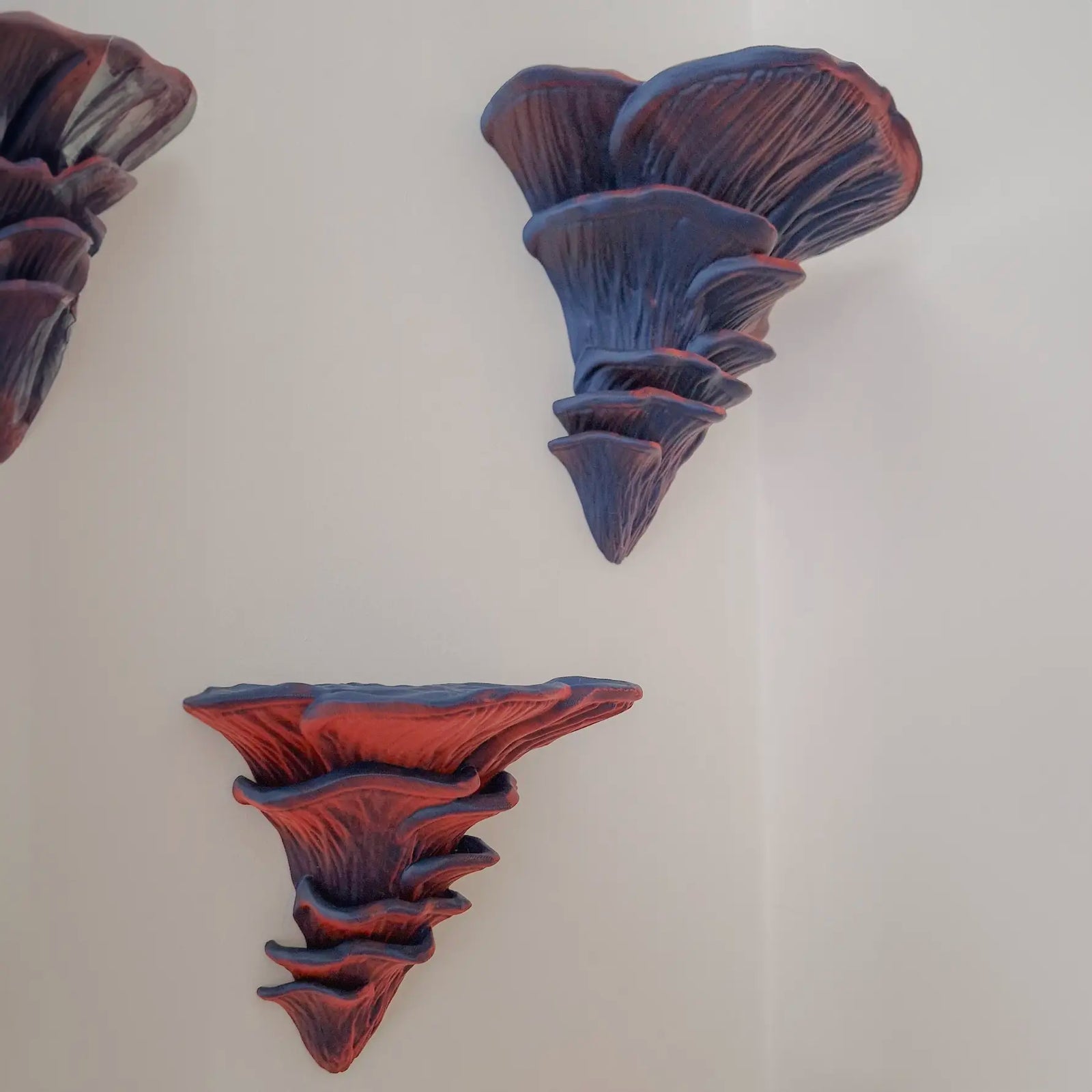 Djamor Fungus Wall Shelf mounted in a living room with decorative items. Mixed berries color.