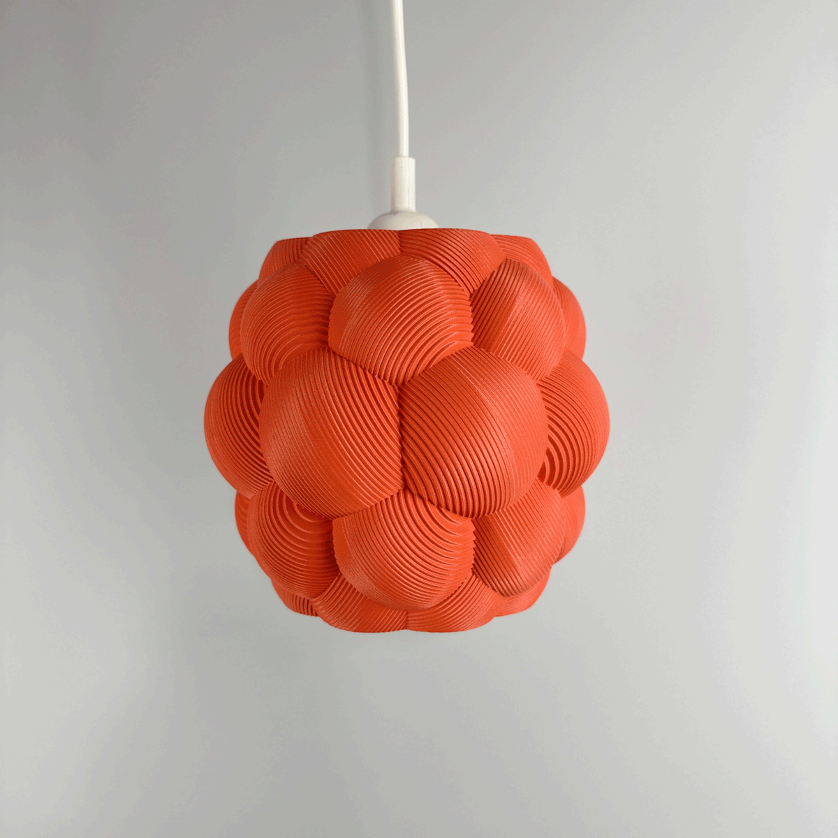 3D printed Apo Malli lampshade in modern design in muted red biodegradable material. Used with 400k LED bulb on and off