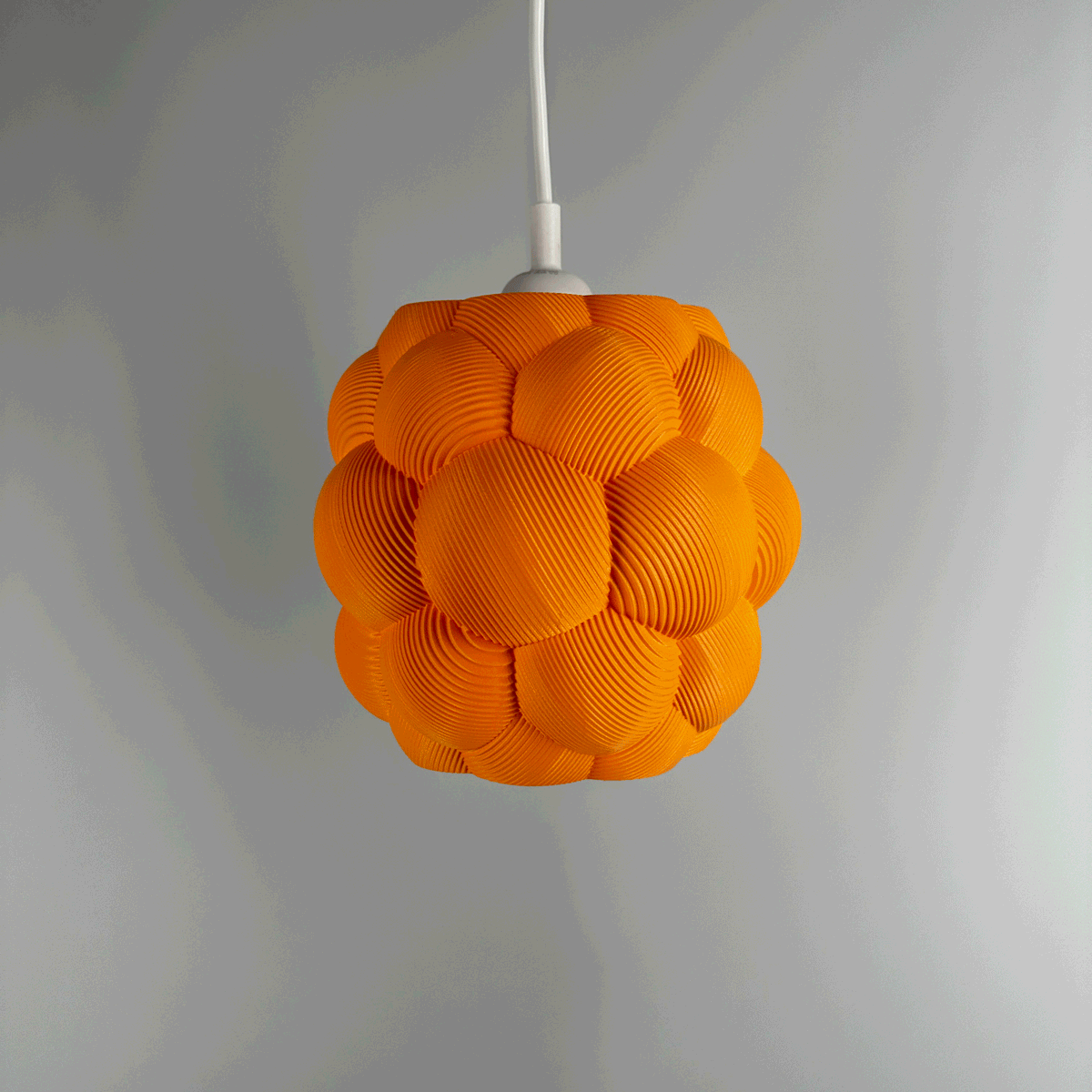 3D printed Apo Malli lampshade in modern design in orange biodegradable material. Used with 400k LED bulb on and off