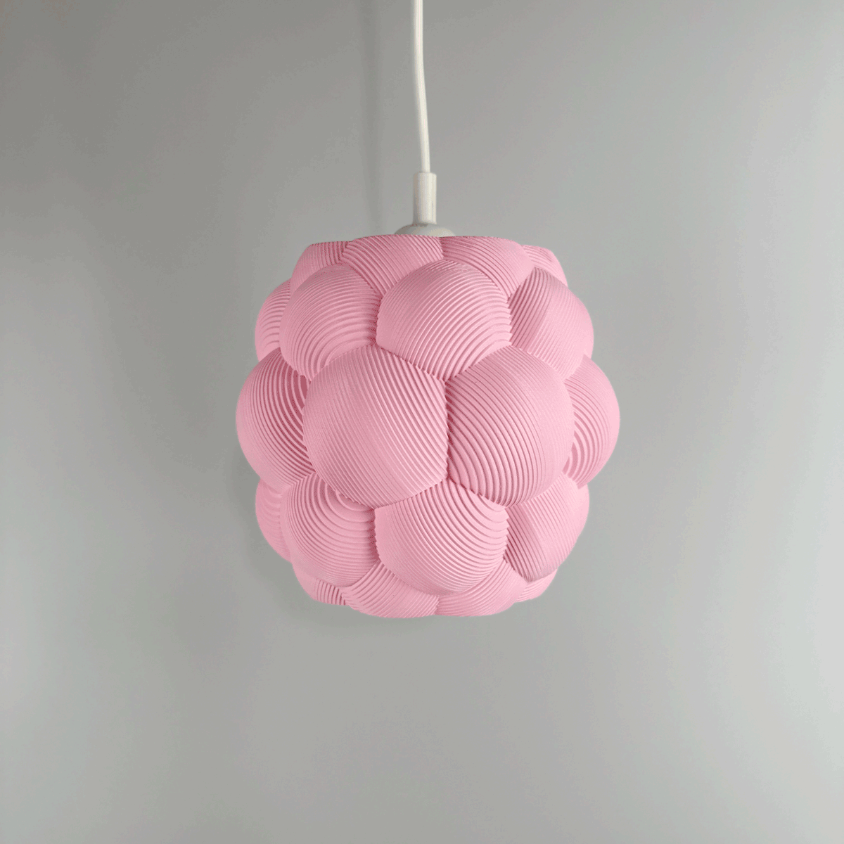 3D printed Apo Malli lampshade in modern design in sakura pink biodegradable material. Used with 400k LED bulb on and off