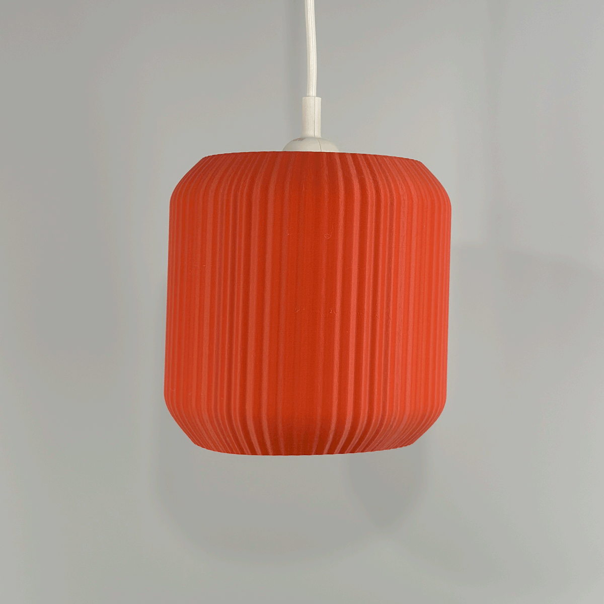 Lucash lampshade in muted red- onn and off, adding a vibrant touch to modern home settings with its unique 3D printed structure.